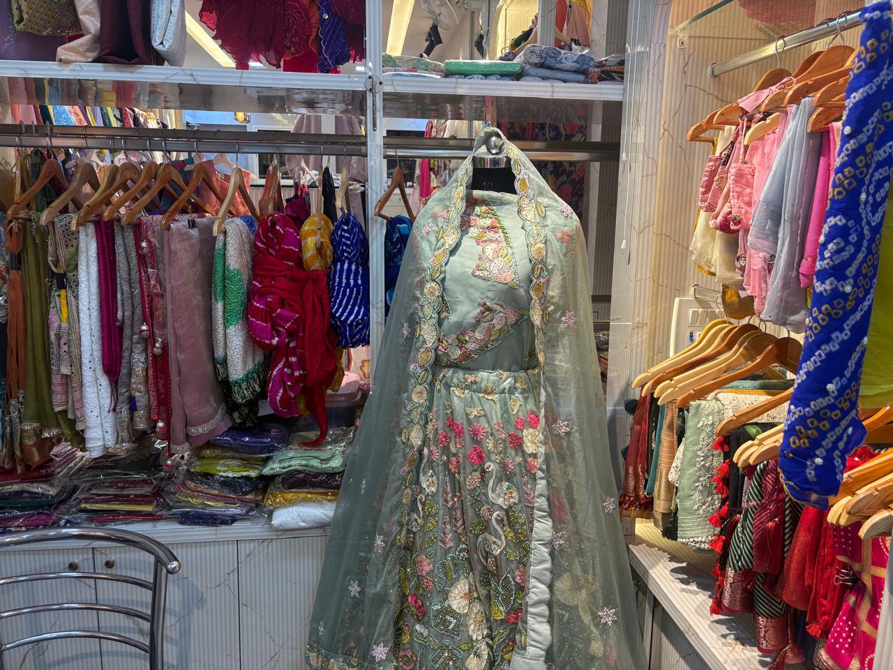 boy in smart casual navy cashmere sweater and olive green trousers leaning against a stone wall